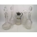 Four glass decanters together with a glass claret jug