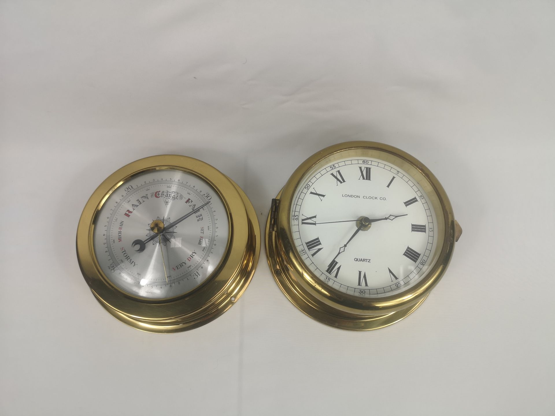 Brass London Clock Co. wall clock together with a brass barometer