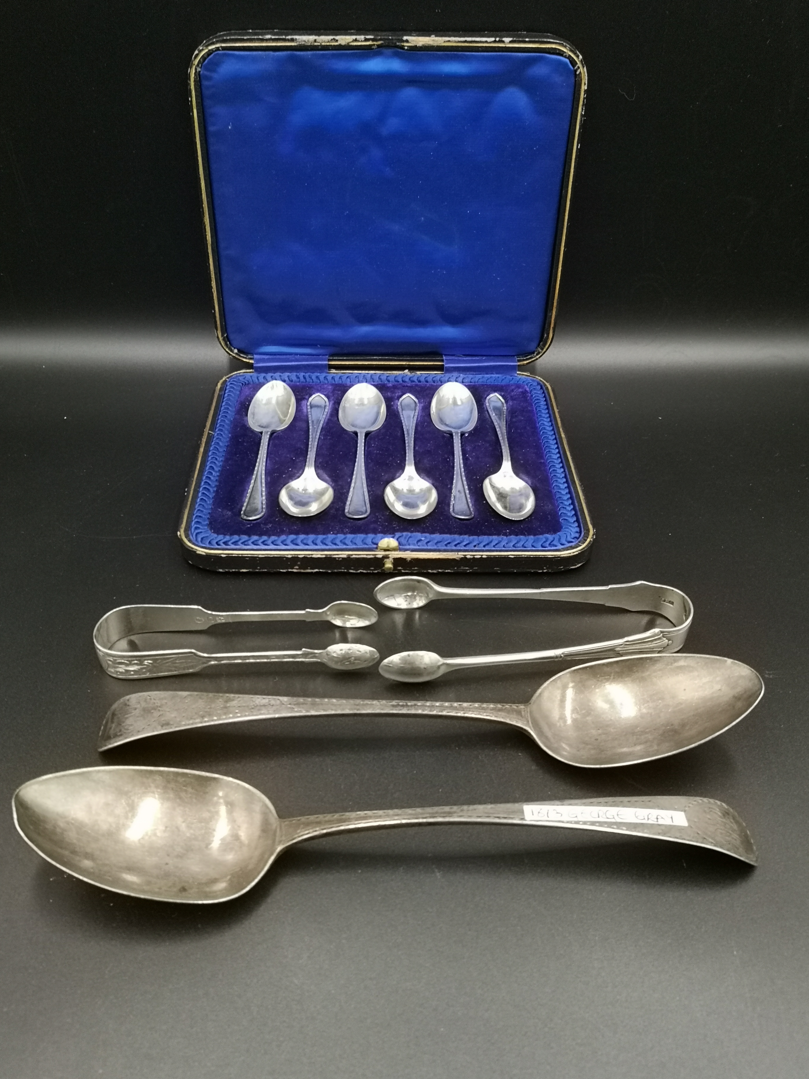 Boxed set of silver tea spoon, two silver serving spoons and two silver sugar tongs