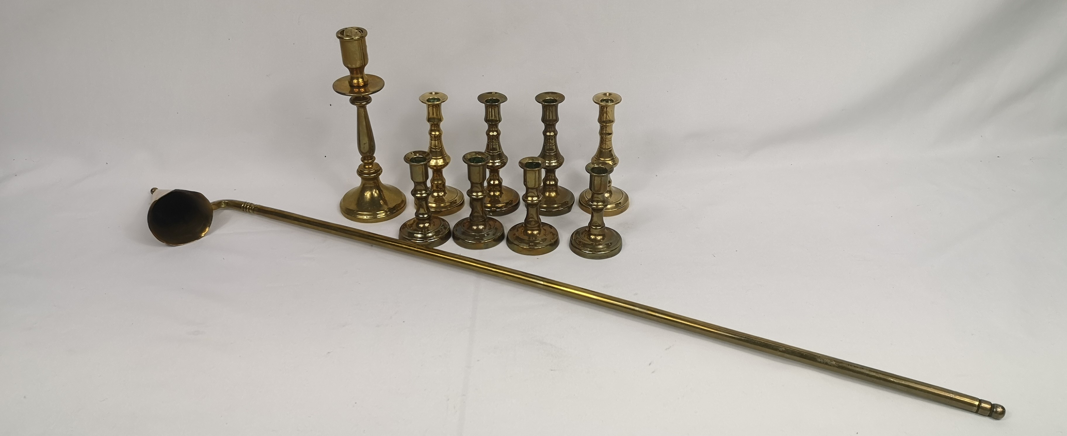 Four pairs of brass candlesticks