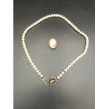 Cameo brooch together with a pearl necklace