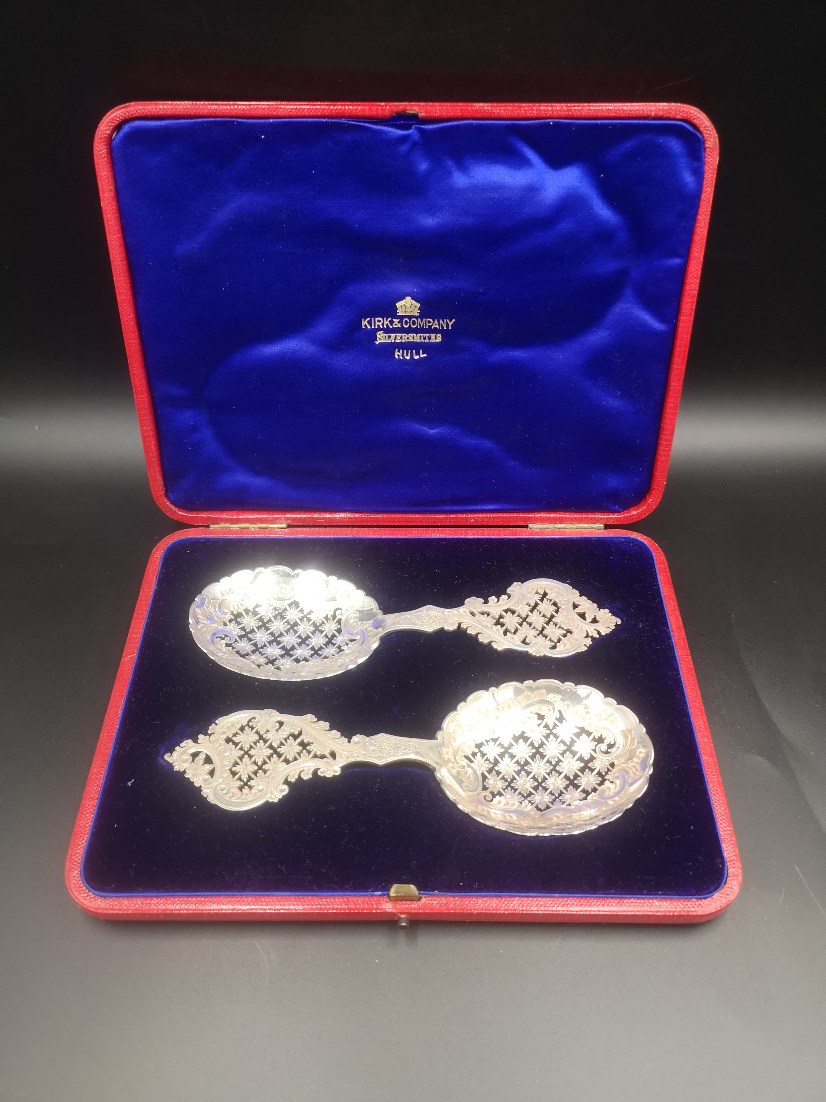 Box containing a pair of pierced and engraved silver spoons