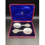 Box containing a pair of pierced and engraved silver spoons