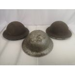 Three WWII steel military helmets.