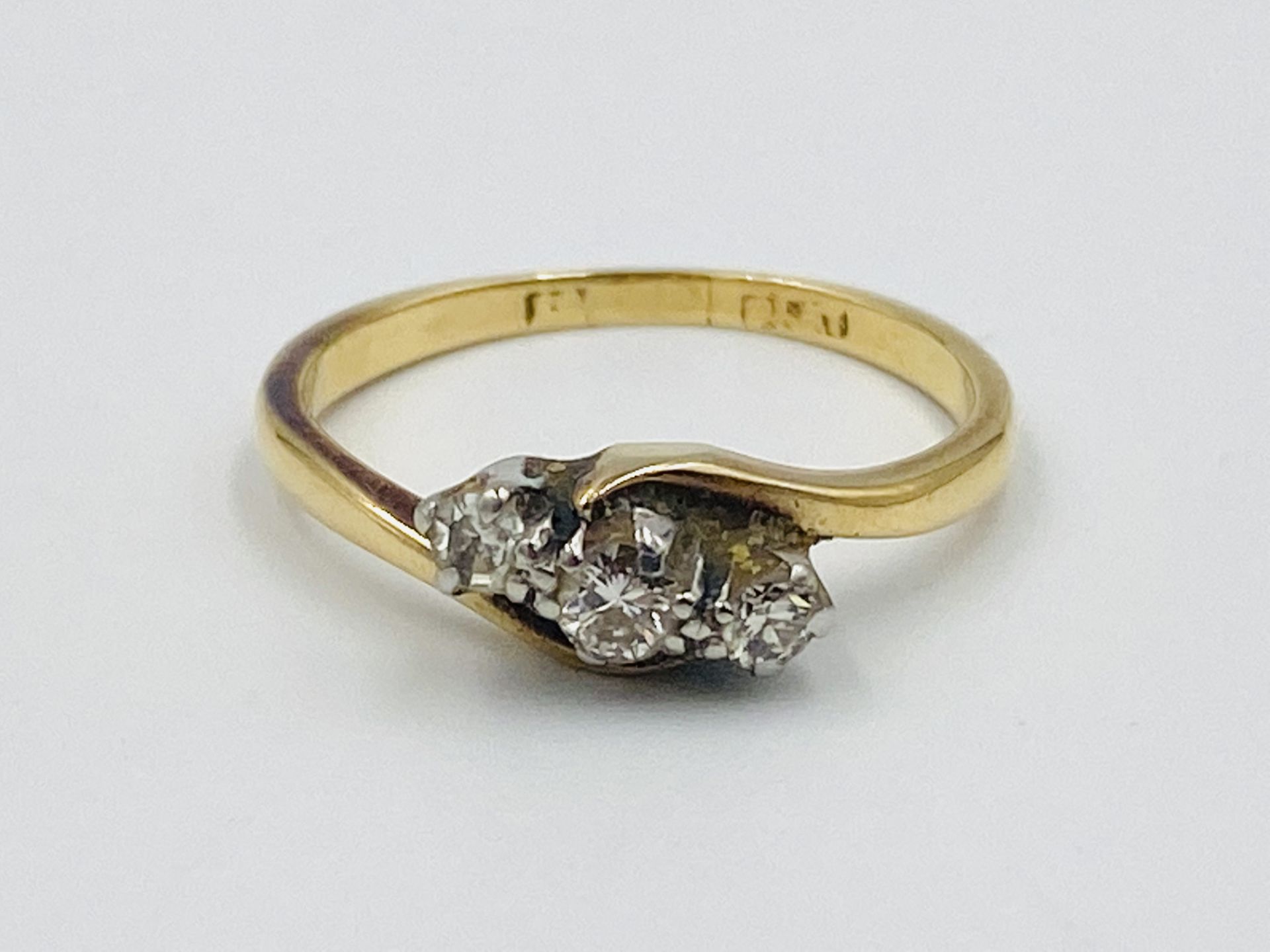 Yellow metal three stone diamond ring
