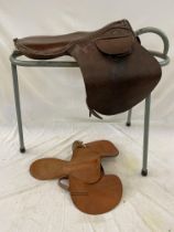 Brown leather child's saddle approx 14", together with a small light brown leather jockey's saddle