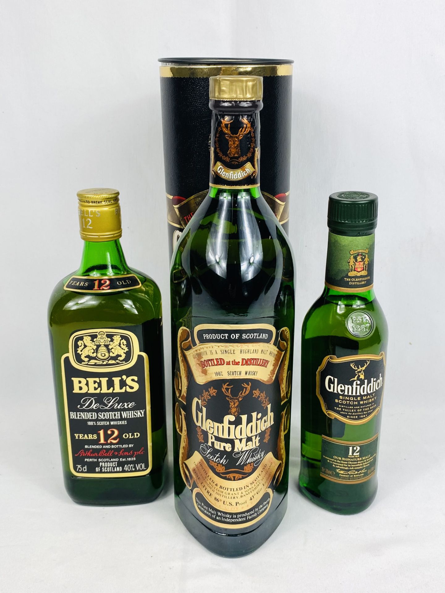 Two bottles of Glenfiddich whisky and a bottle of Bells whisky