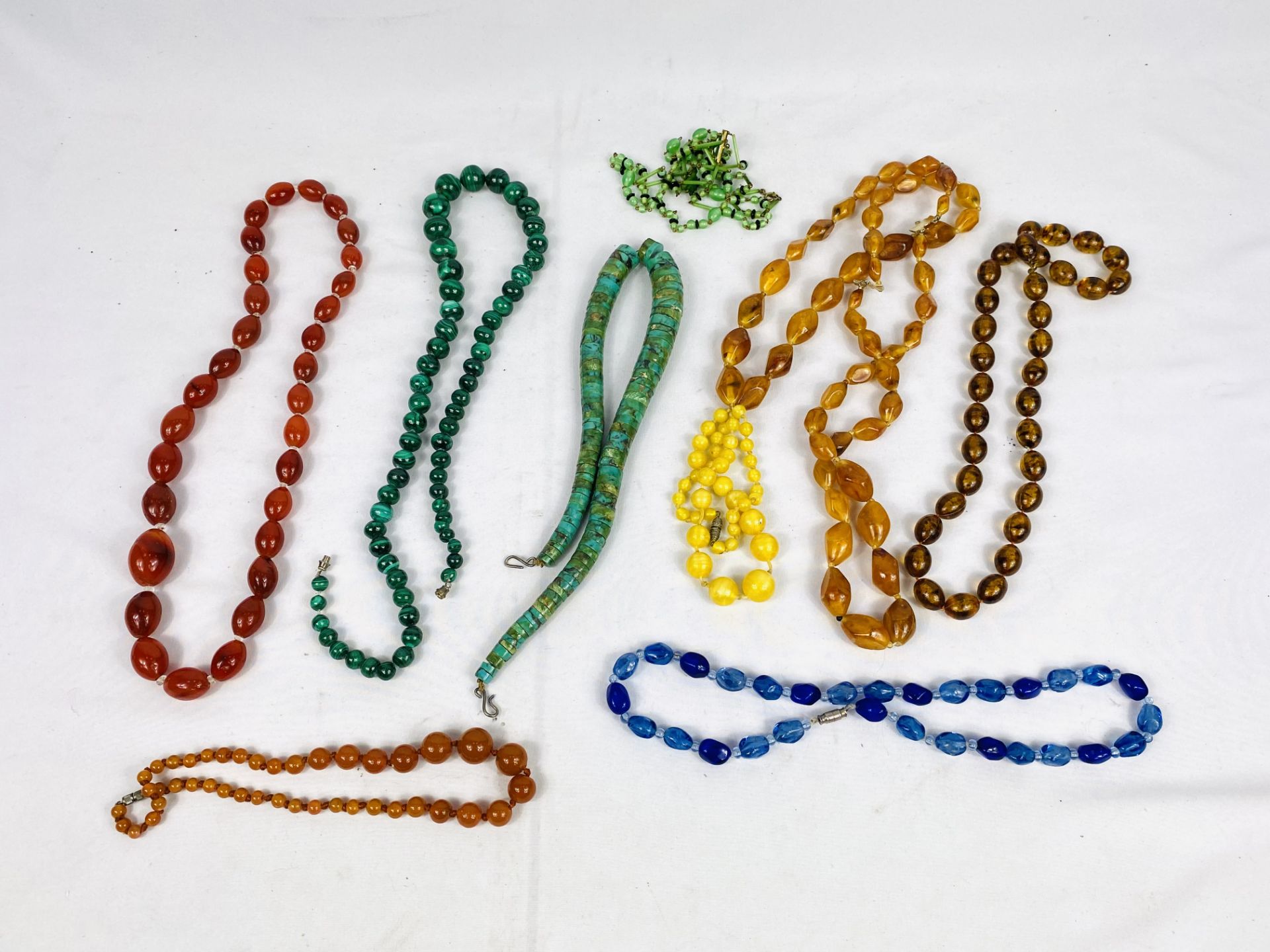 A malachite bead necklace together with a quantity of other bead necklaces