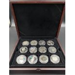 Twelve commemorative silver £5 coins.