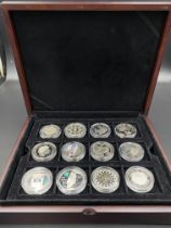Twelve commemorative silver £5 coins.