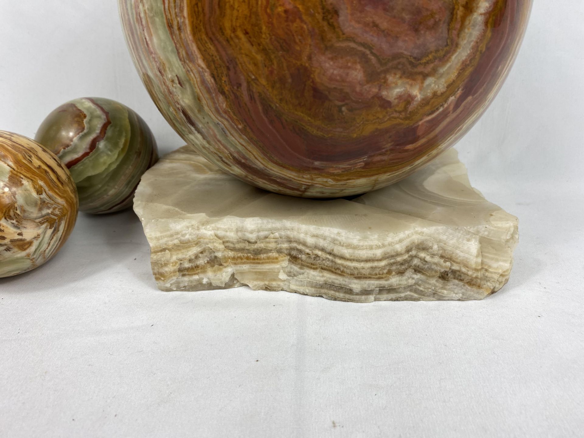 An onyx ball on marble base together with two smaller balls - Image 4 of 5