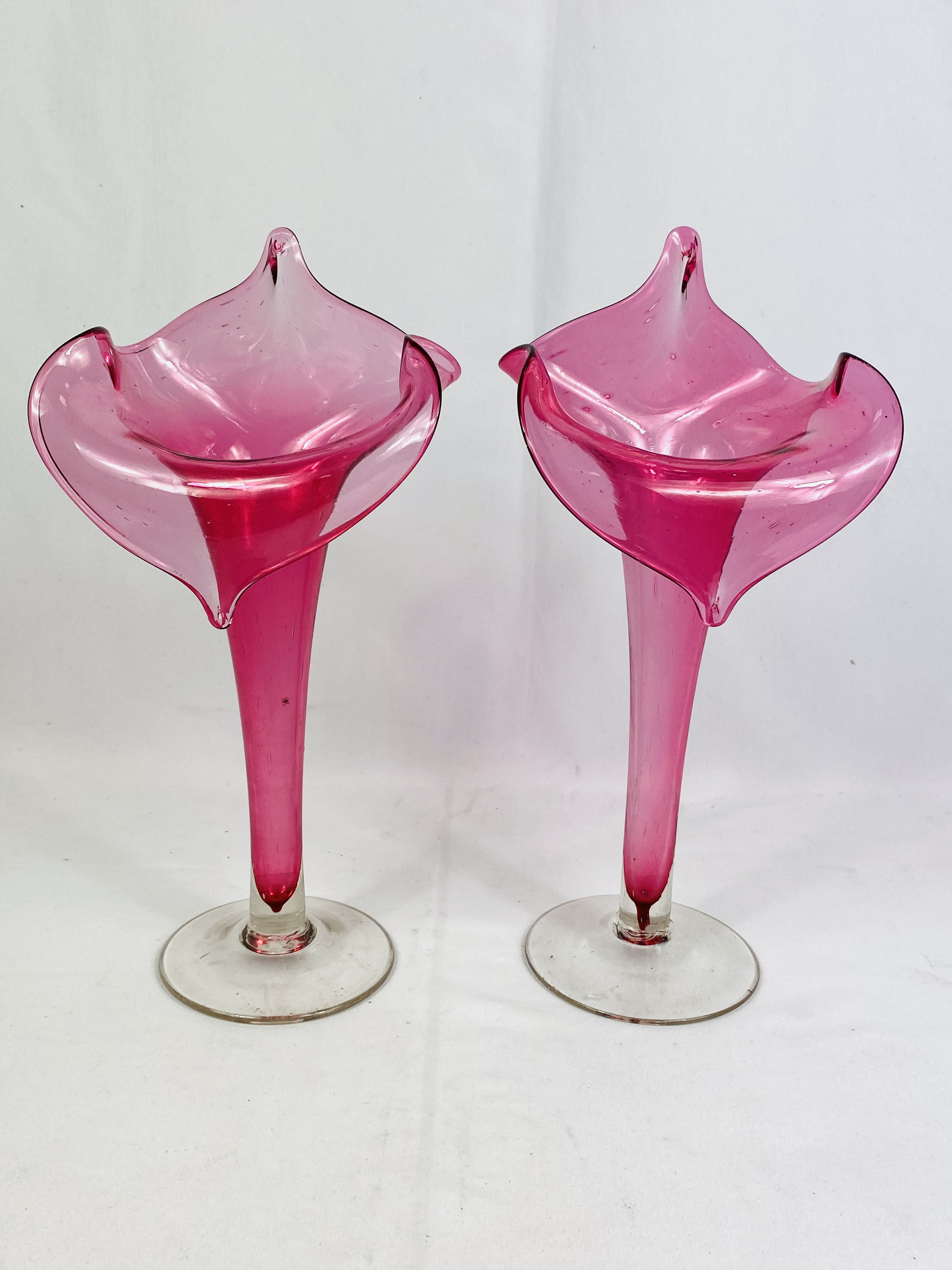 A pair of cranberry glass 'preacher in the pulpit' glass vases