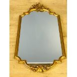 Gilt framed wall mirror with carved detailing to top