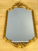 Gilt framed wall mirror with carved detailing to top