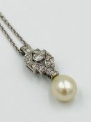 A natural pearl and diamond pendant on a platinum chain