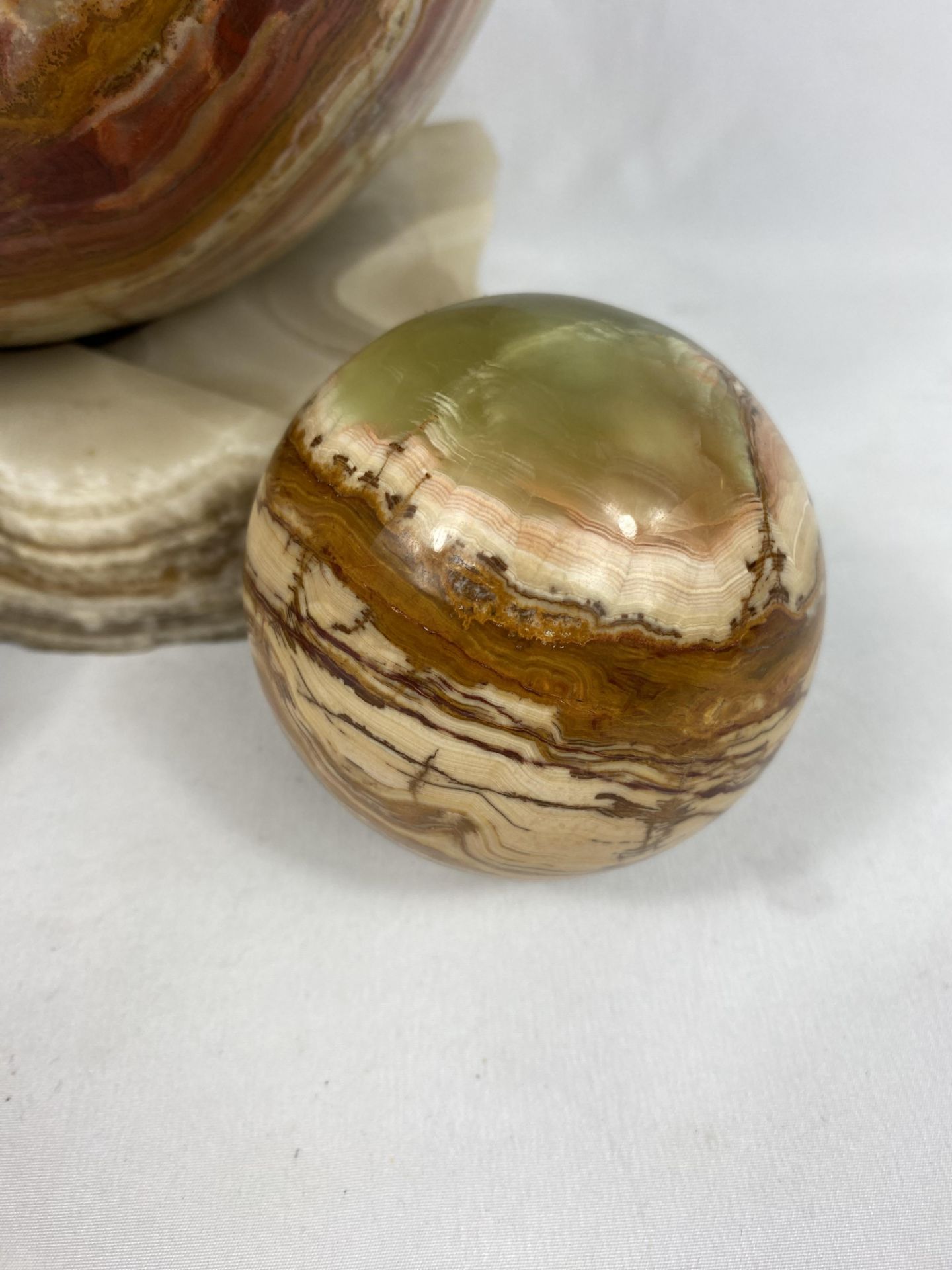 An onyx ball on marble base together with two smaller balls - Image 3 of 5