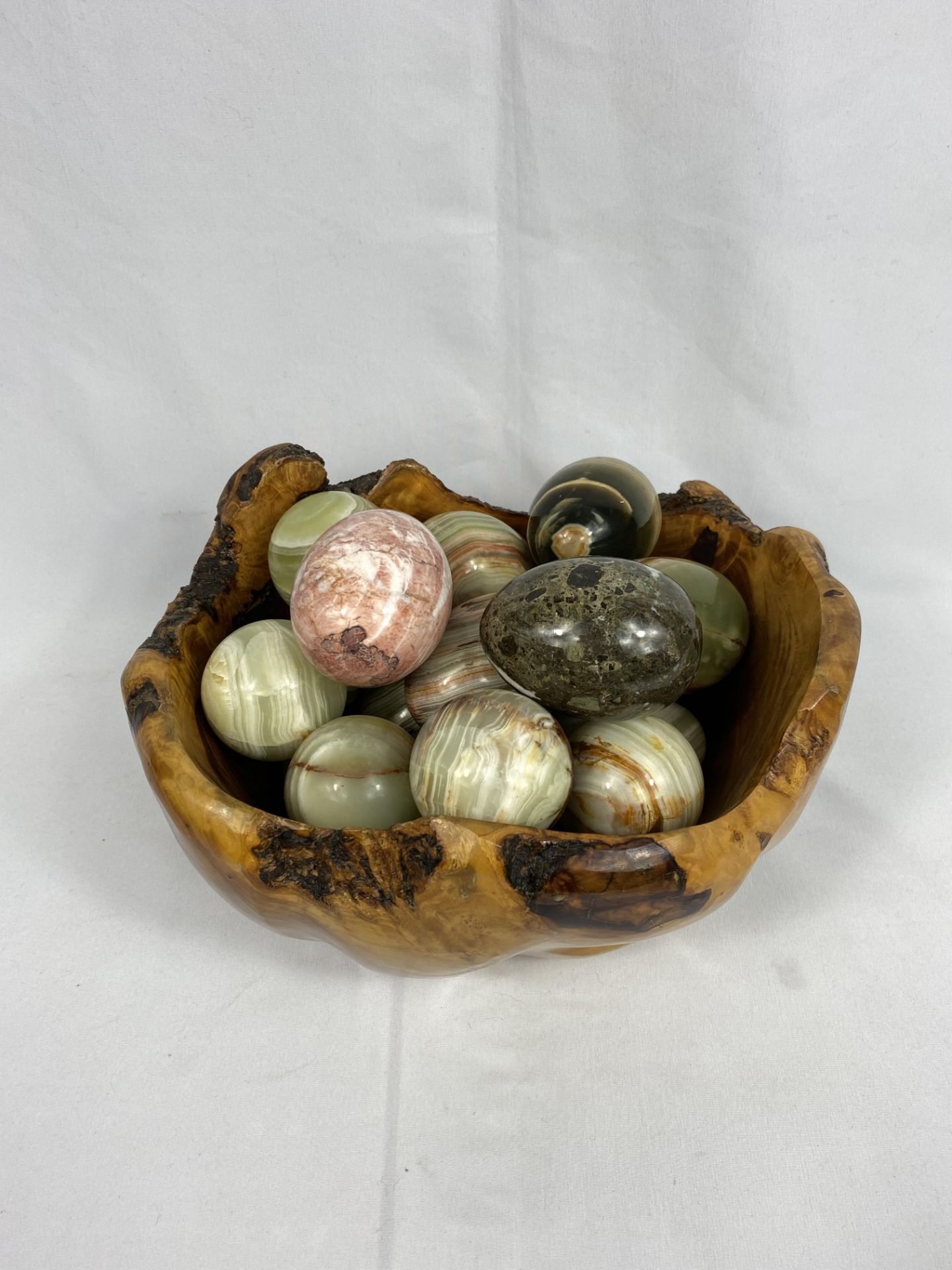 A wood bowl containing a quantity of wood and stone eggs