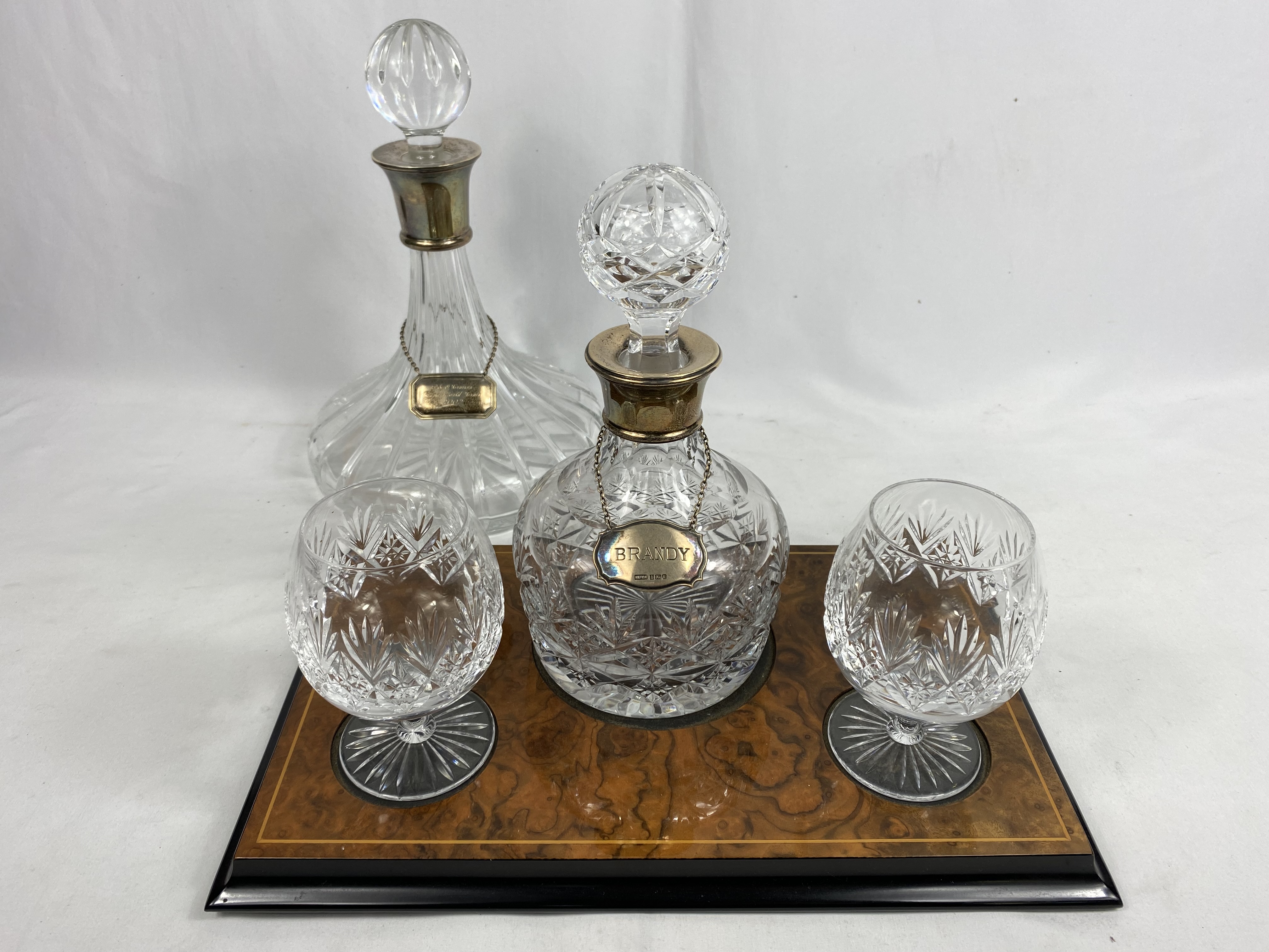 Contemporary cut glass brandy decanter and glass set, together with a decanter with a silver collar