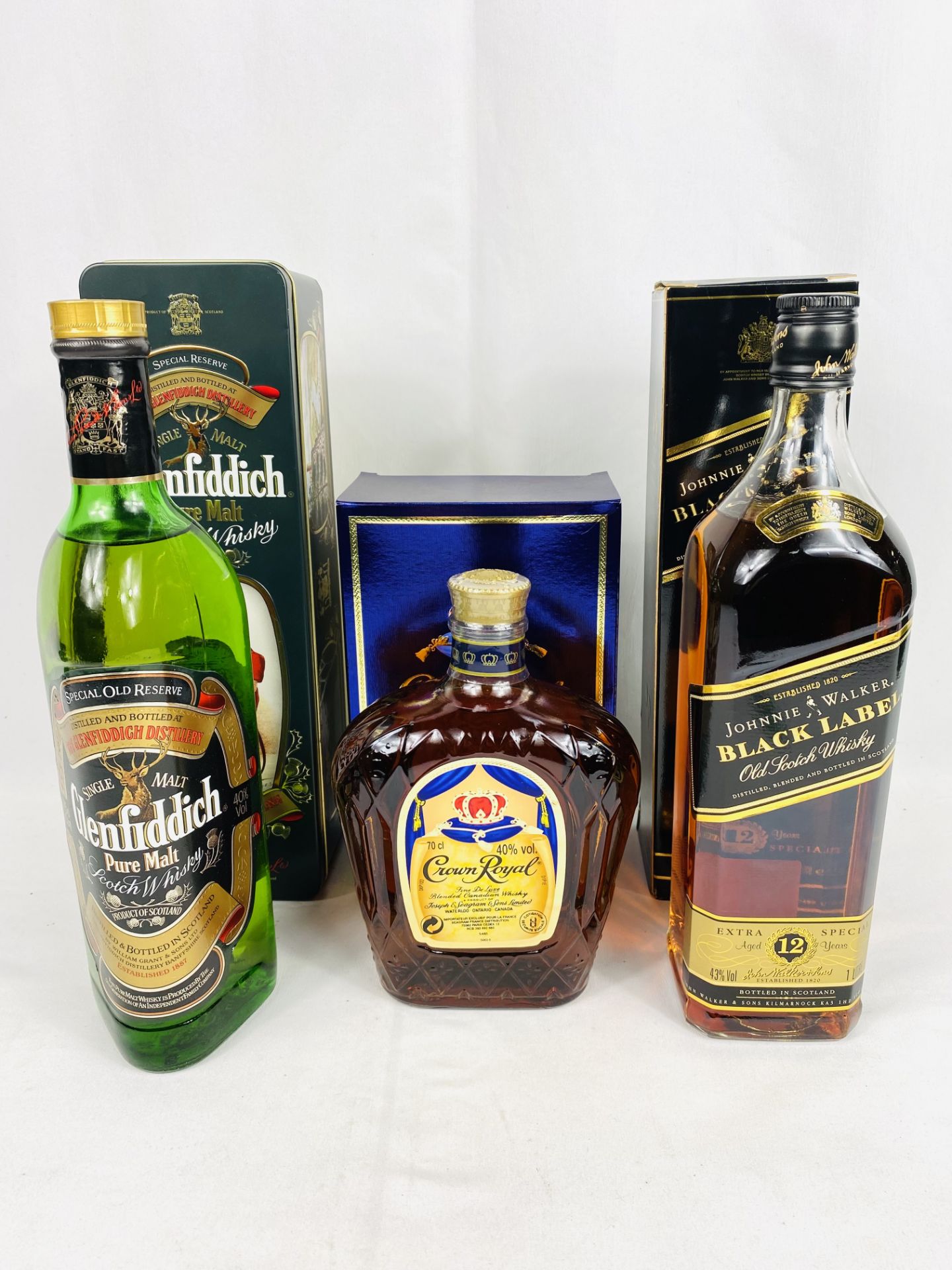 A bottle of Glenfiddich Scotch whisky and two other bottles of whisky