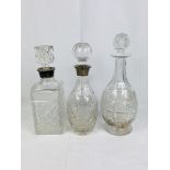 Two cut glass decanters with silver collars and a cut glass decanter