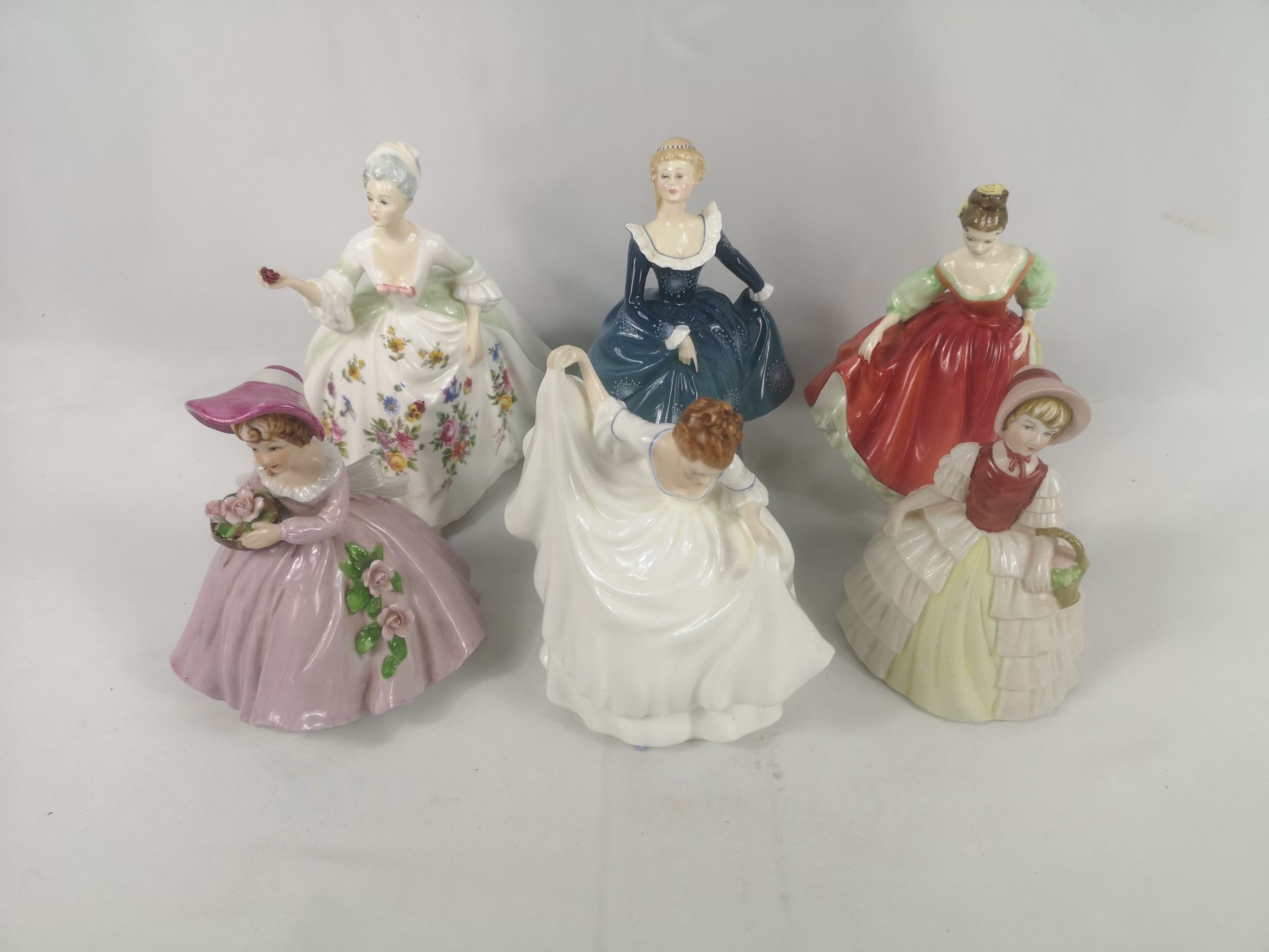Six porcelain figurines to include four Royal Doulton