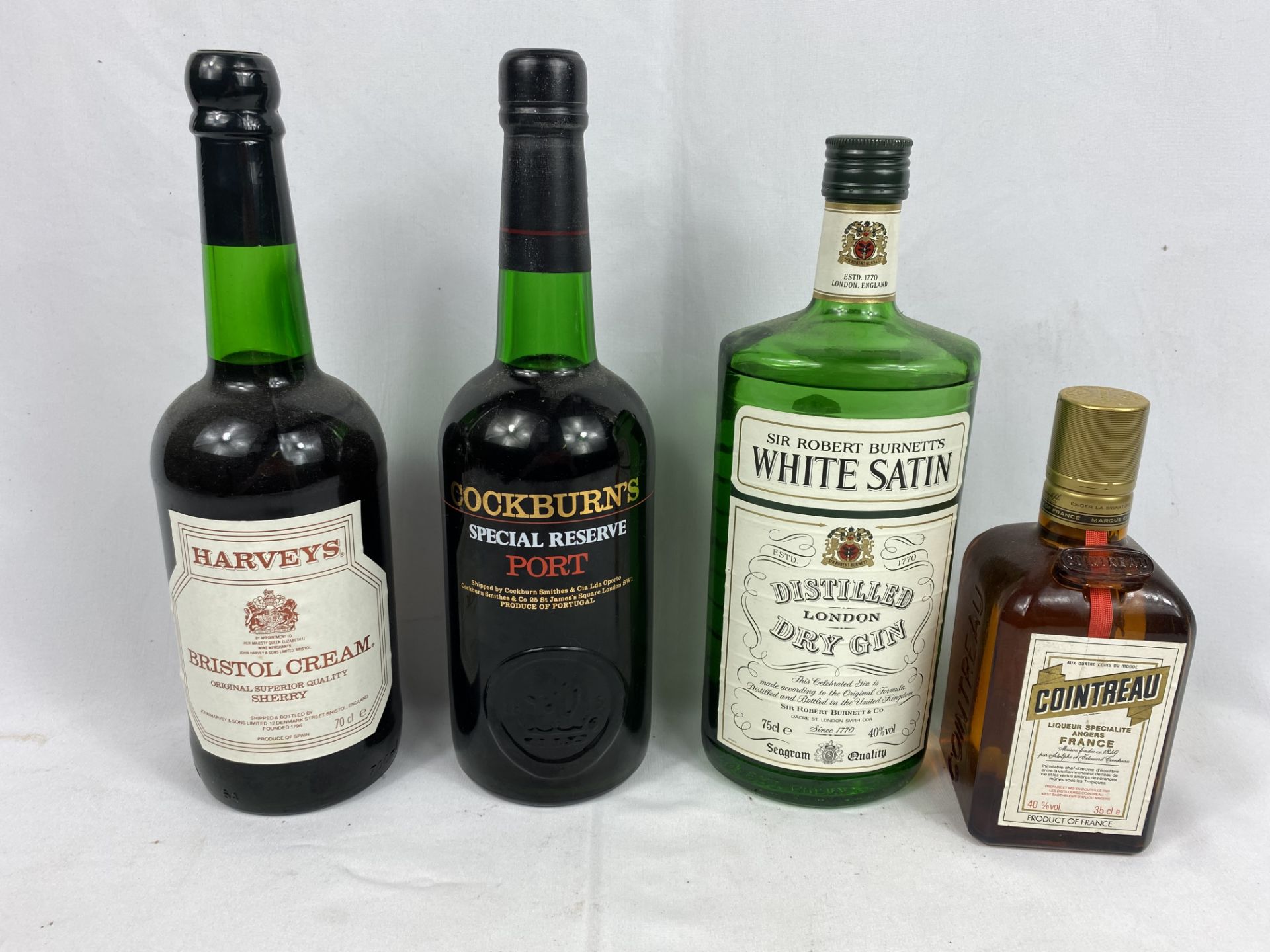 Bottle of Cockburn's Special Reserve port, a bottle of gin and two other bottles