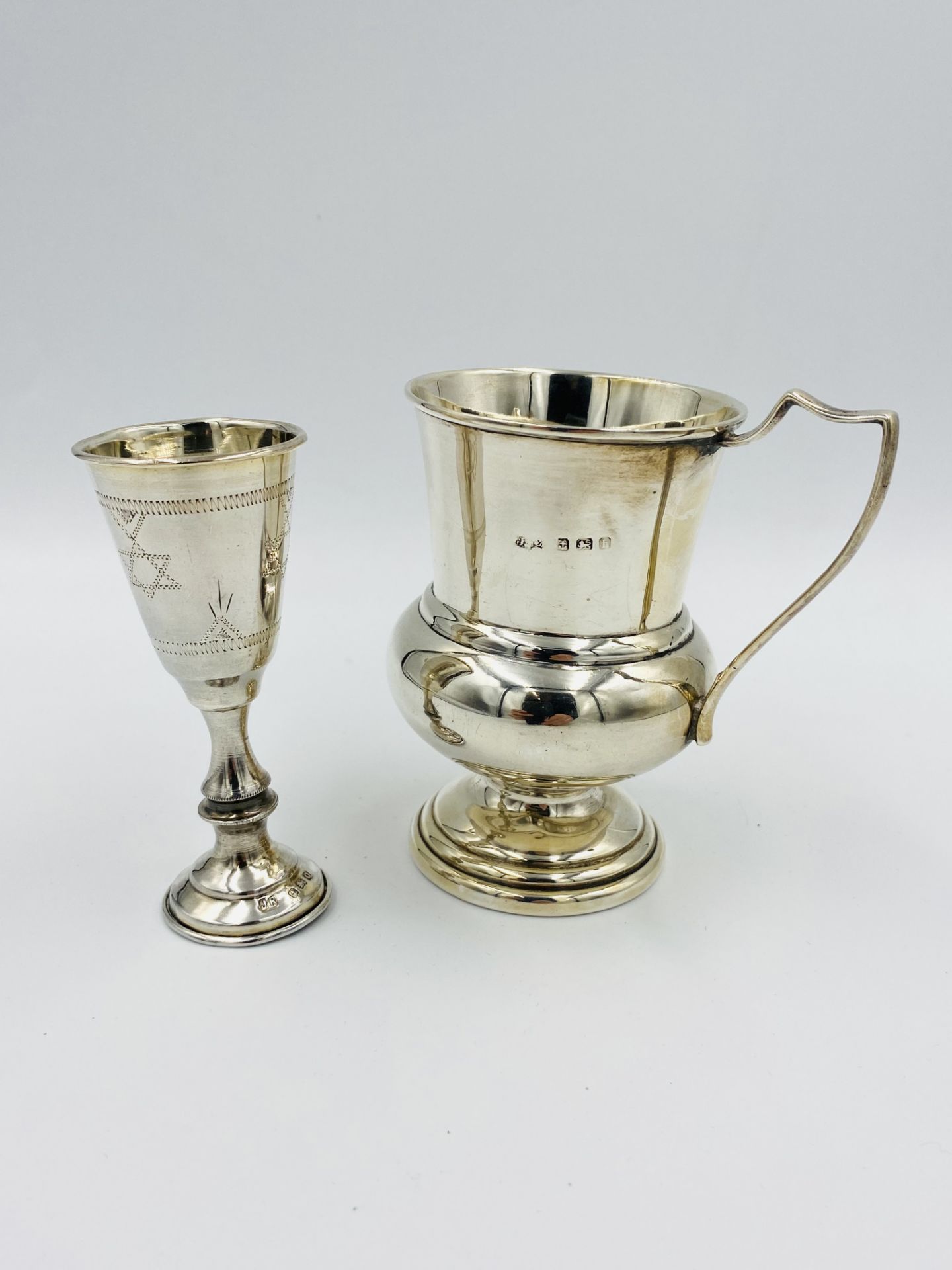 Two silver cups and a silver framed clock