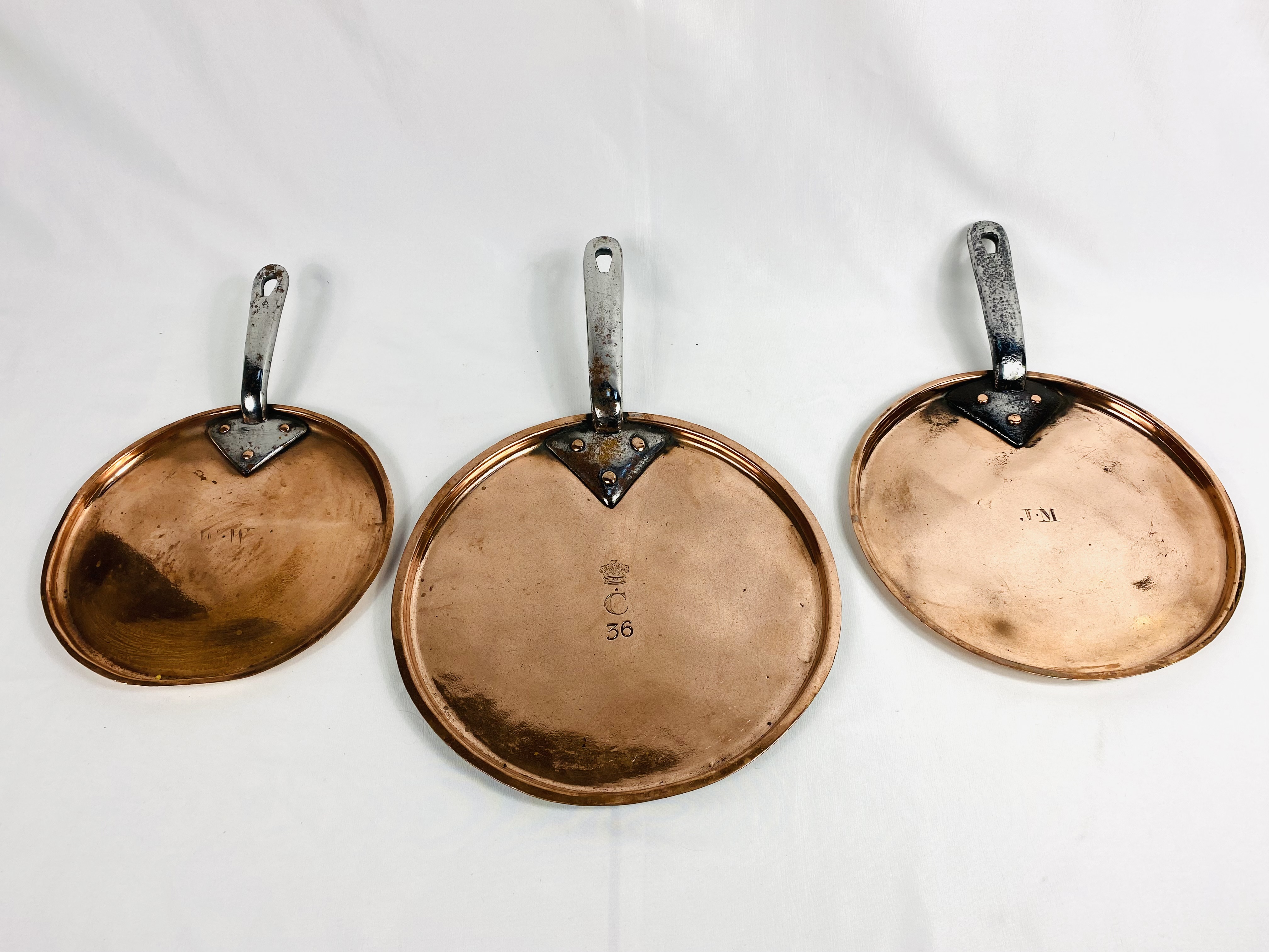 Three Victorian copper saucepan lids with steel handles