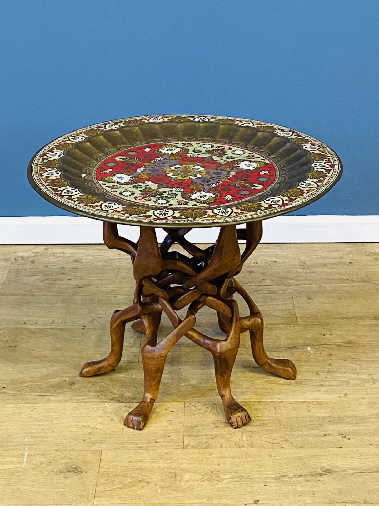 Painted brass tray on carved wood stand