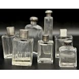 Seven silver topped glass dressing bottles (7)