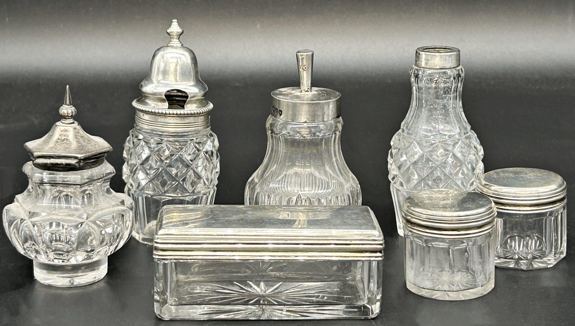 Seven silver topped glass jars (7)