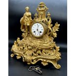 French gilt spelter figural clock, twin train 8cm enamel dial with Roman numerals, mounted by a