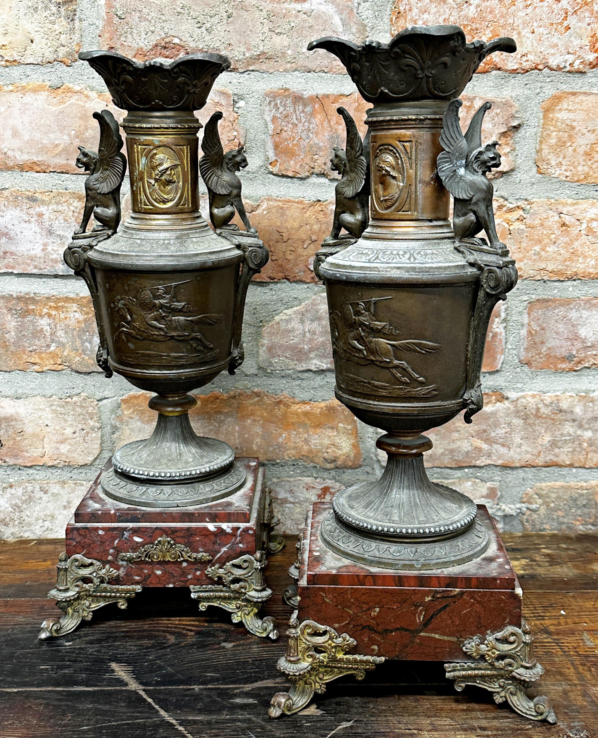 Pair of French cast mental twin handled garniture vases, repoussé decoration of Roman soldier on