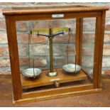 Teak glazed case of precision scales by De Grave Short & Co Ltd of London, 45cm wide