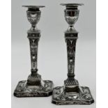 A pair of Victorian silver weighted candlesticks, marks rubbed, the urn sconces above a tapering