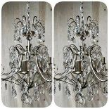 A contemporary pair of silvered metal crystal drop chandeliers with various glass prismatic drops,