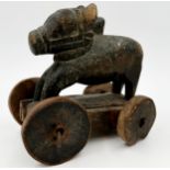 Carved Indian folk art treen Nandi bull on wheels, traces of original paint, 21cm long