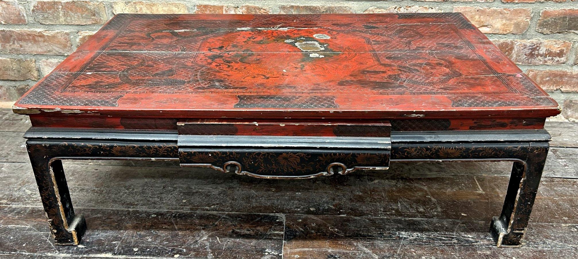 Antique Chinese red lacquered coffee table, decorated with dragons and griffins, 33cm high x 97cm