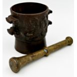 Antique pestle and mortar, cast iron mortar cast with a crest to both sides and case brass pestle,