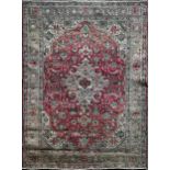 Heriz carpet, with medallion and scrolled decoration on a red ground, 310 x 200cm