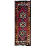 Good full pile Afghan runner with red motifs on a blue ground, 290 x 110cm