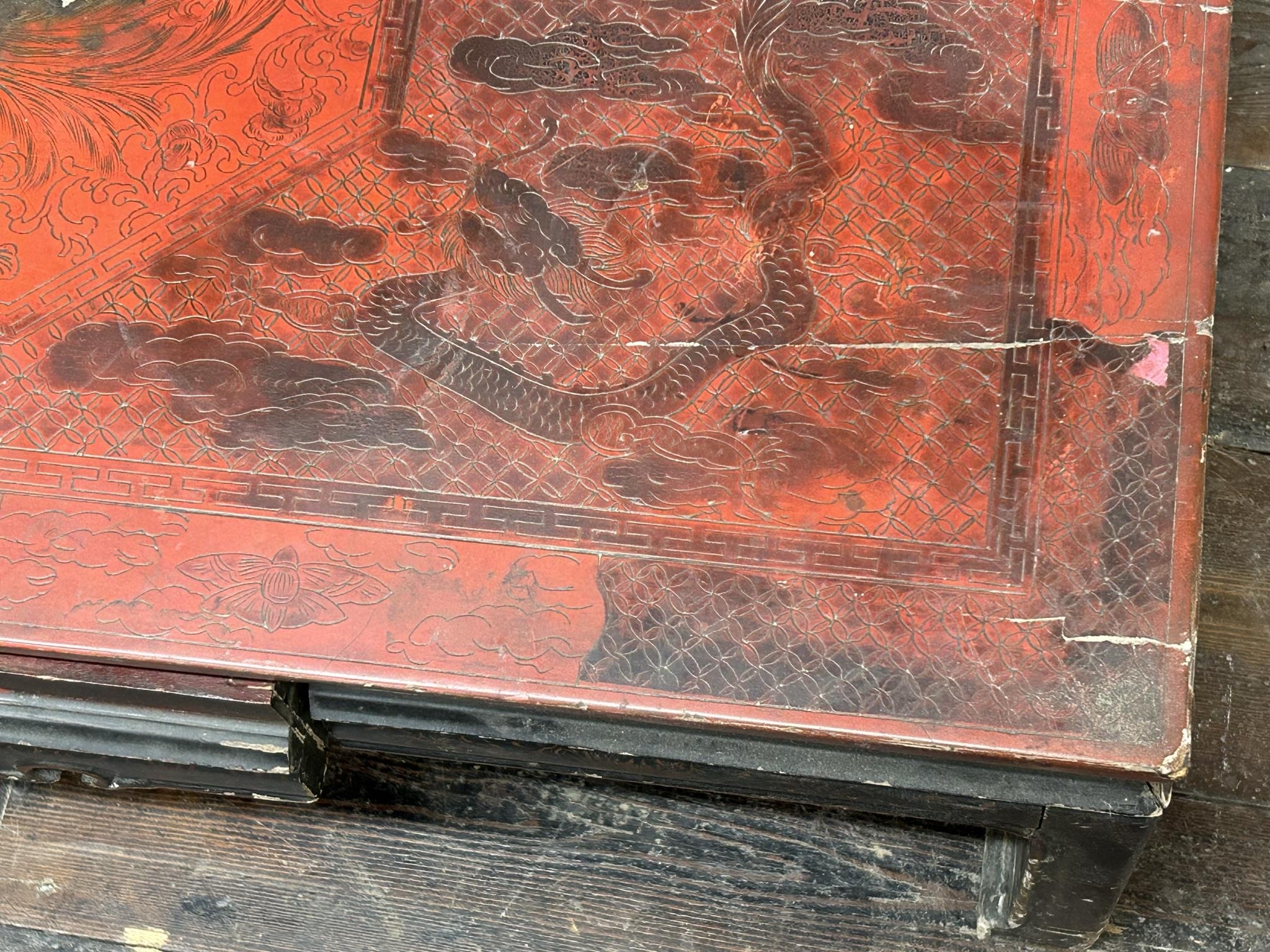 Antique Chinese red lacquered coffee table, decorated with dragons and griffins, 33cm high x 97cm - Image 3 of 3