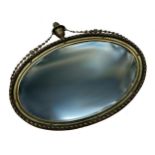 Regency period giltwood and gesso oval wall mirror, mounted by a flambeau finial, original