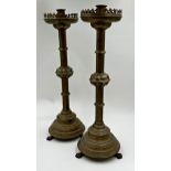 Large pair of ecclesiastical brass gothic candlesticks, with raised club turrets and paw feet,