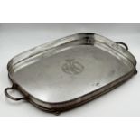 Large silver plate oval tray with pierced gallery sat upon four ball feet with carrying handles.