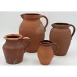 Harlequin set of four graduated terracotta jugs, the largest 28cm high