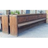 Pair of antique pitch pine church pews/settles, the panelled backs complete with book shelf,