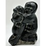 Inuit soapstone carving of a tribesman with seal, 25cm high.