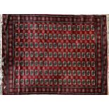 Large Wilton bokhra wool with typical geometric medallion design upon a red ground, 350cm x 250cm.