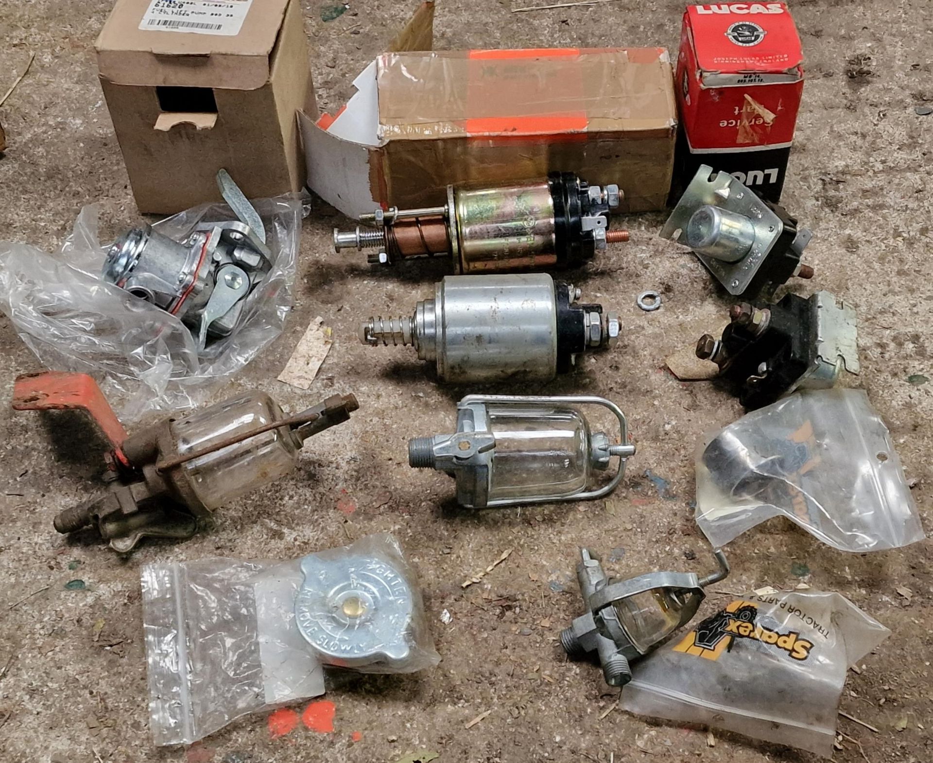 Collection of vintage tractor parts to include petrol tank filter, coils, fuel lift pump, 12v